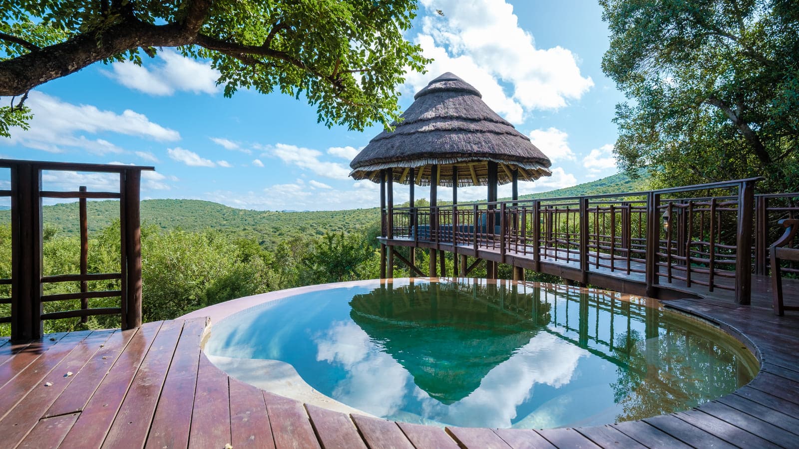 A luxury safari lodge deck with an infinity pool overlooking the hills